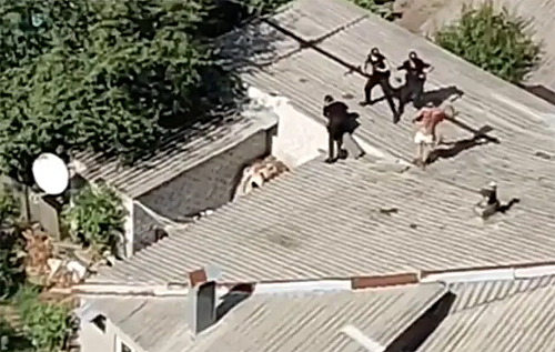 В Харькове голый психбольной дрался на крыше дома с полицией. Один коп сорвался вниз. ВИДЕО
