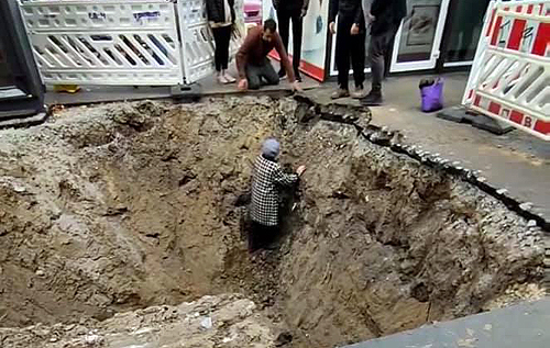 В Киеве прохожие вытащили бабушку, упавшую в вырытую коммунальщиками яму. ВИДЕО