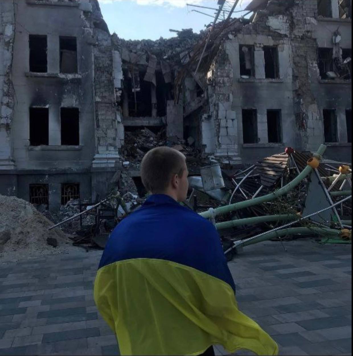 Юнак з прапором України вийшов на площу біля розбомбленого маріупольського Драмтеатру. ФОТО